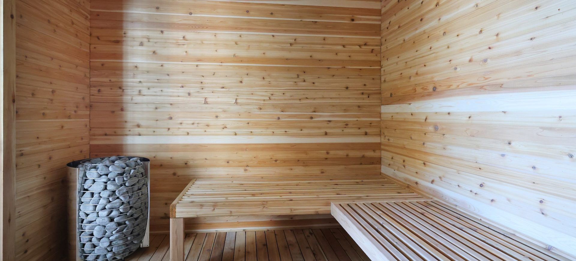 Indoor sauna with natural cedar wood paneling and bench seating at Station 250 luxury apartment amenities Mundelein