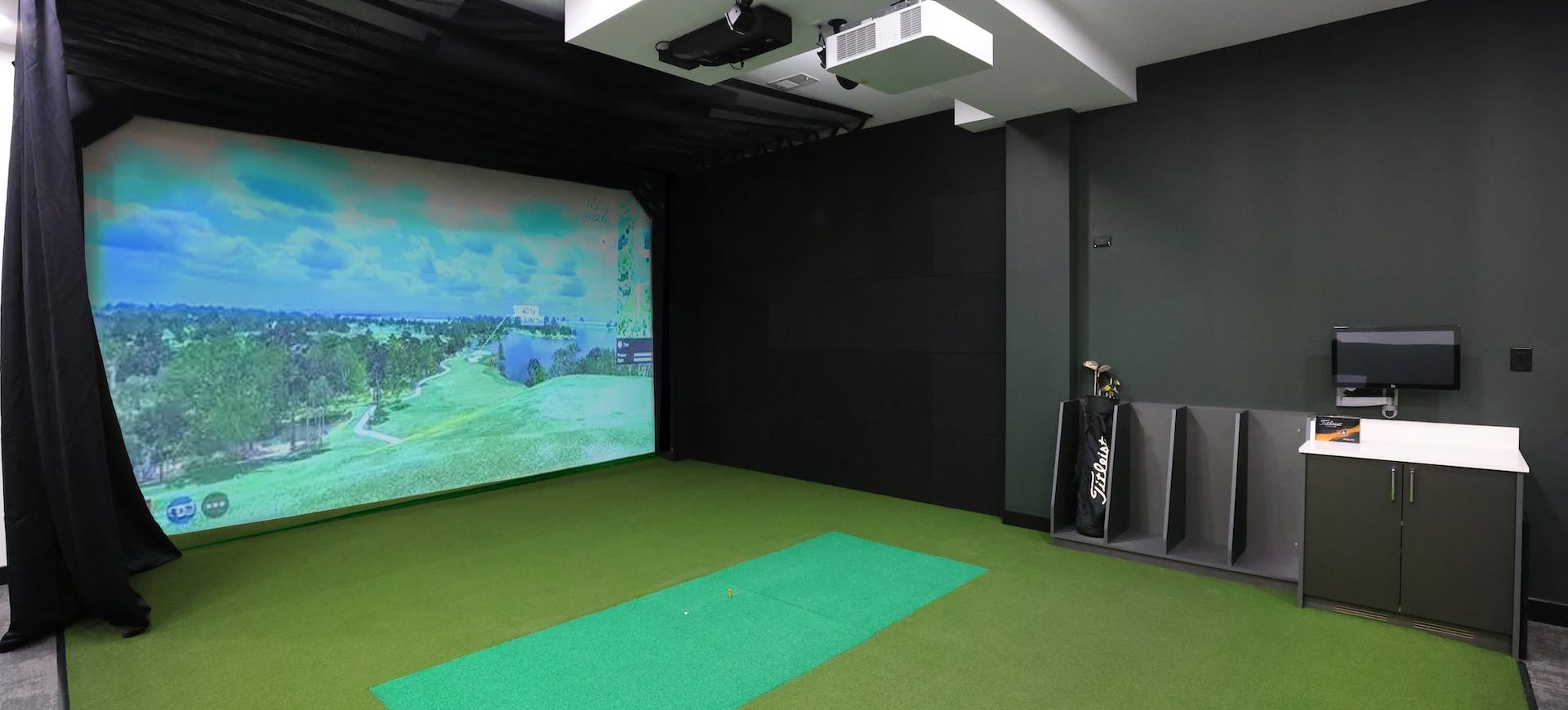 Station 250 indoor golf simulator room with projection screen and professional golf equipment Mundelein IL"